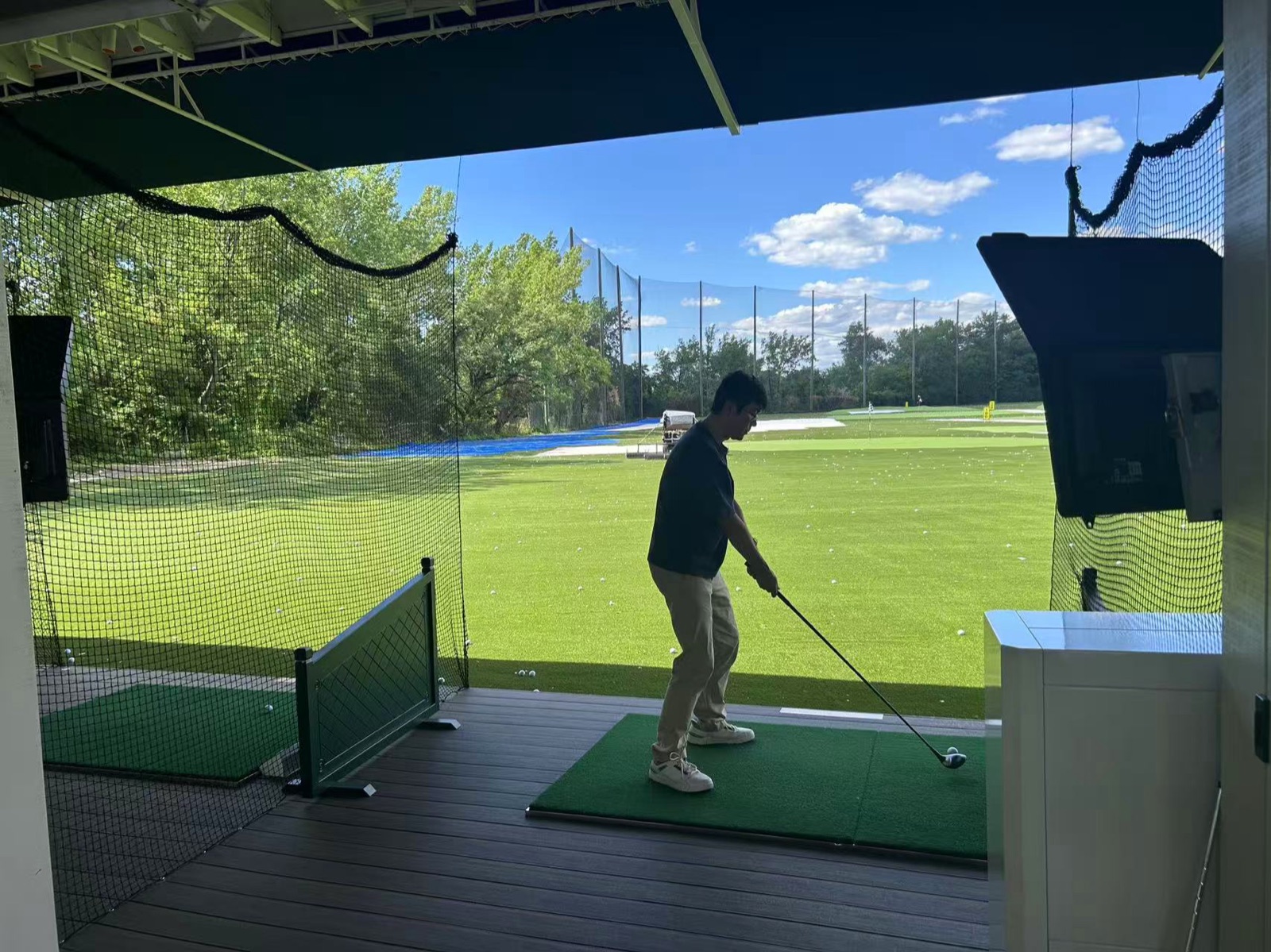 A participant practices at the driving range