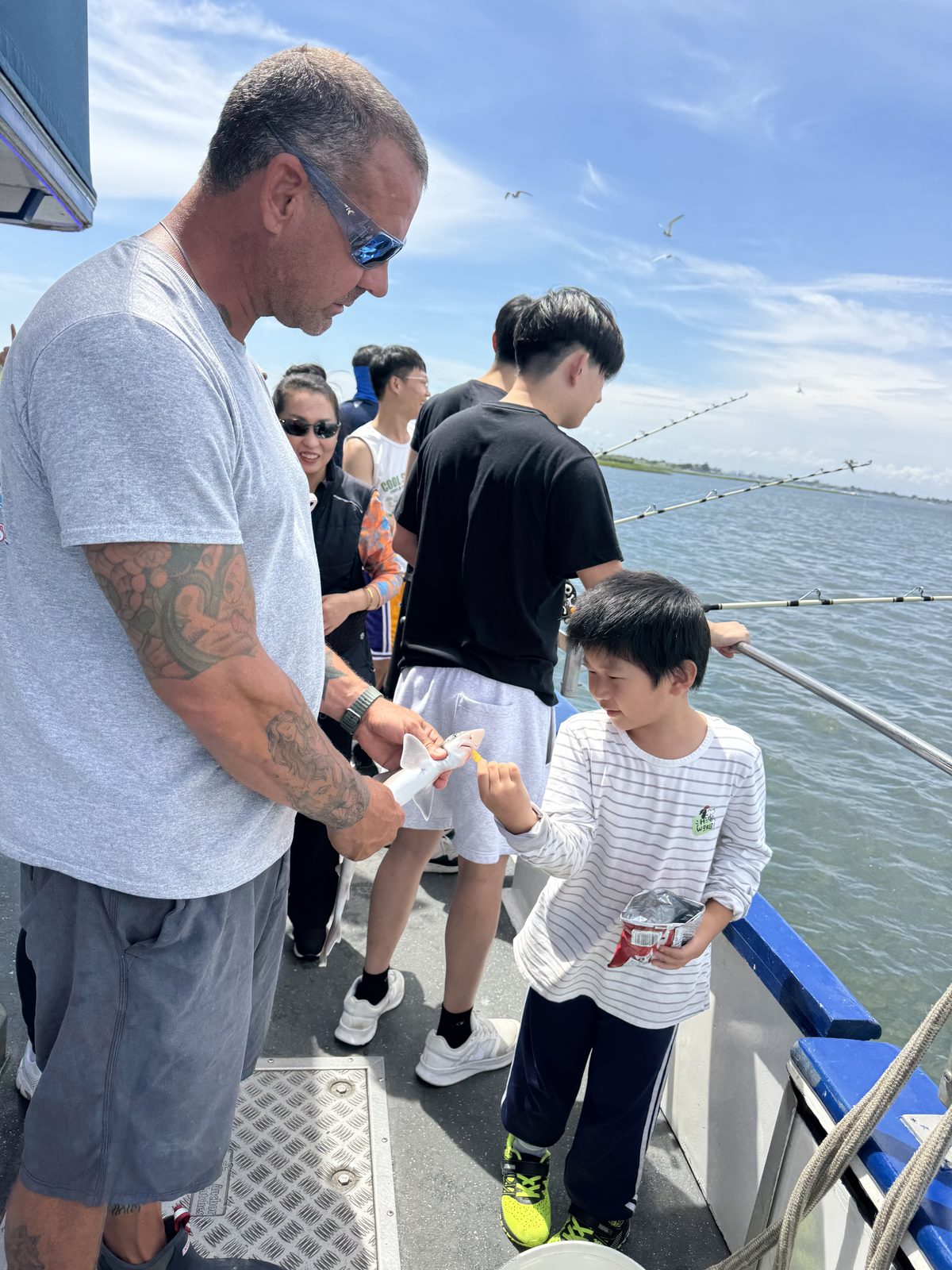 A young angler proudly holds up his catch