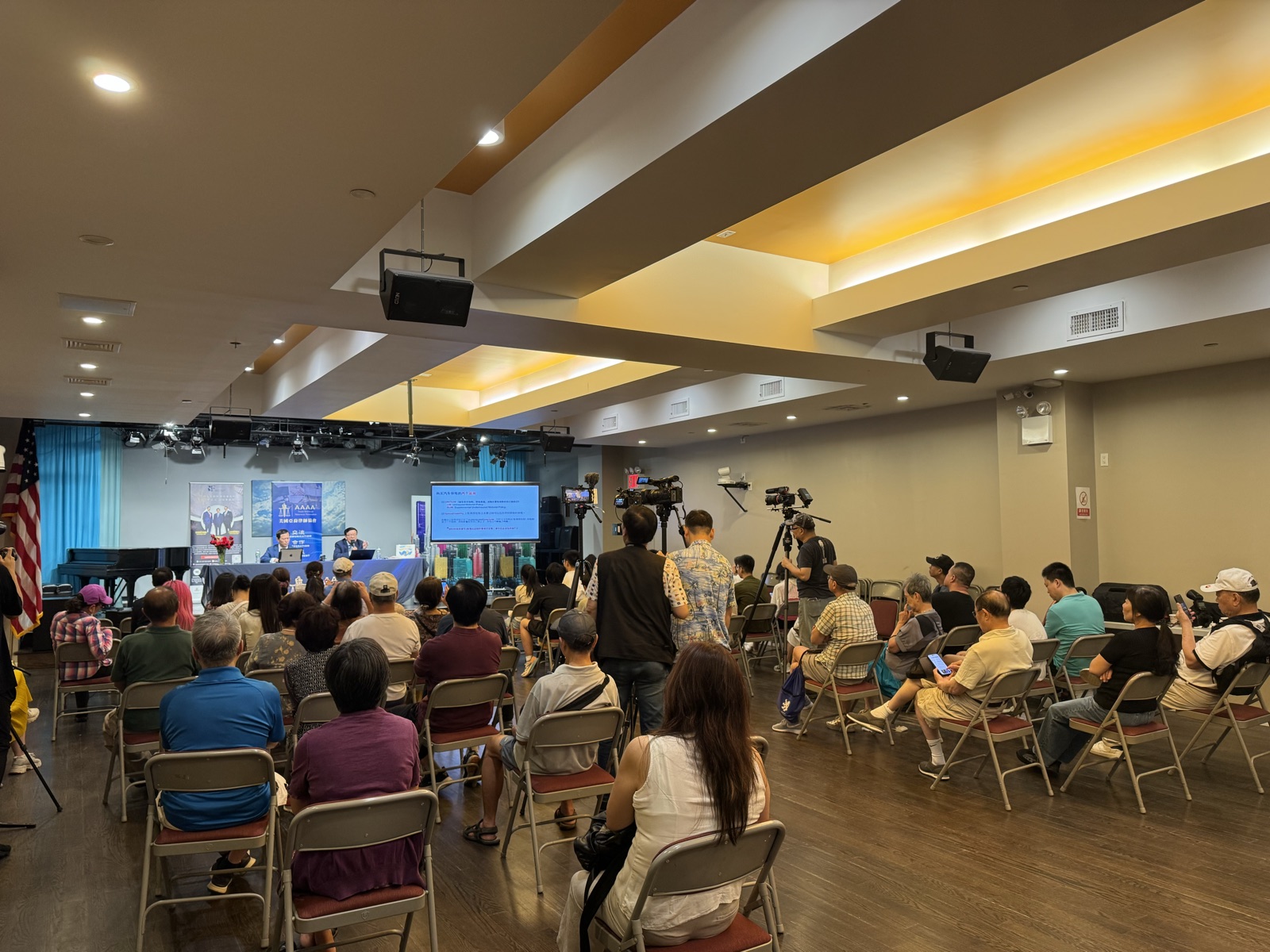 Community members and media fill the venue